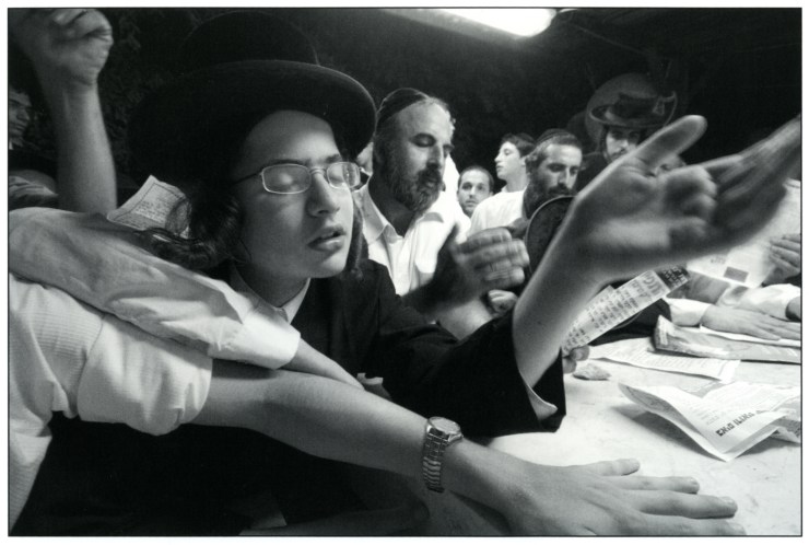 1 Een chassidische jongen bidt vol overgave bij het graf van de tzadiek van Shtefanesht, rabbijn Avraham Mattisyahu Friedman. Tel Aviv, 2006. De tzadiek stierf in 1933. Zijn stoffelijke overschot werd in 1969 naar Israël gebracht. Foto: Yuval Nadel, Israël Museum. 