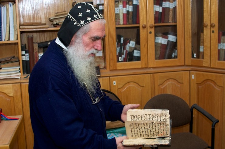 Pater Shemun in de biblitheek van de kerk, met eeuwenoude Aramese documenten. Foto: © Alfred Muller