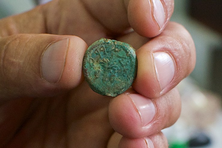 De munt met de loelav en twee citrusvruchten (de trog) met daarom heen de woorden 